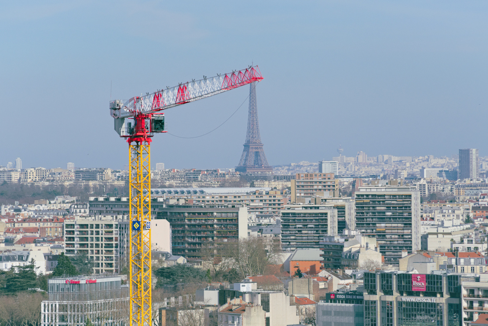 A construction crane set against the Paris skyline and Eiffel Tower